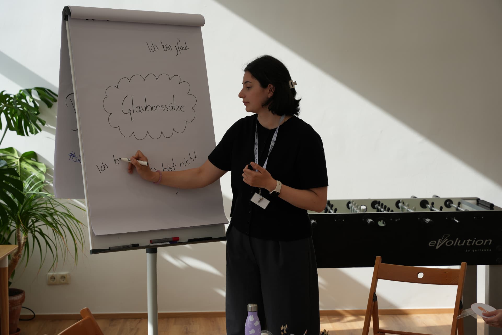 Trainerin schreibt Glaubenssätze auf ein Flipchart